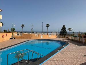 a large blue swimming pool in a building at Precioso apartamento con piscina a 50m de la playa in Candelaria