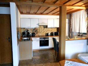 a kitchen with white cabinets and a stove top oven at Ferienwohnung Kraus in Langdorf im Landkreis Regen