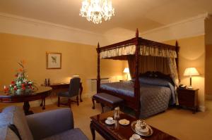 斯特拉凡的住宿－巴博斯特城堡酒店，一间带天蓬床的卧室和一间客厅