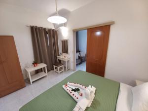a bedroom with a bed with a green table with a cake on it at Litinas Apartments in Agia Marina Nea Kydonias