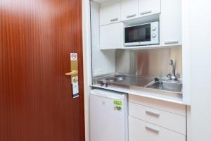 a small kitchen with a sink and a microwave at Aparto Residence Galetamar in Calpe
