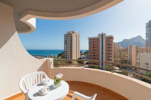 a white table and chairs on a balcony with a view at Aparto Residence Galetamar in Calpe