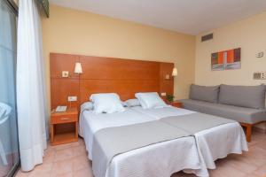 a bedroom with a large bed and a couch at Aparto Residence Galetamar in Calpe