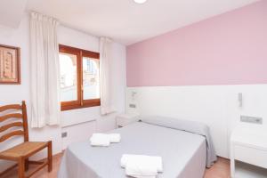 a bedroom with a bed and a chair and a window at Aparto Residence Galetamar in Calpe
