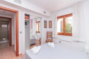 a white bedroom with a bed and a window at Aparto Residence Galetamar in Calpe