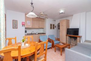 a living room with a dining room table and a kitchen at Aparto Residence Galetamar in Calpe