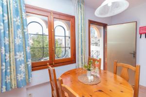 a dining room with a wooden table and a window at Aparto Residence Galetamar in Calpe