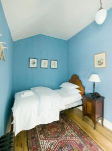 Dormitorio azul con cama y mesa con lámpara en Castletown Gate House, en Celbridge