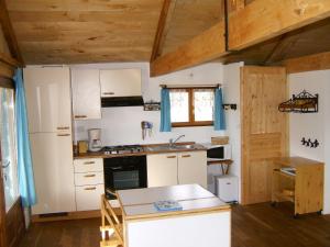 - une cuisine avec des appareils blancs et des plafonds en bois dans l'établissement Paysannerie des Versanes - Chambres et gîte, à Tour-de-Faure