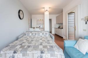 een slaapkamer met een groot bed en een blauwe bank bij A Balcony on Lake Maggiore in Belgirate
