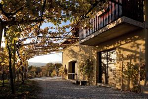 un bâtiment avec un balcon au bord d'une route dans l'établissement Vineyard Cottage Brodaric, à Metlika