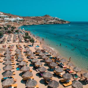 a beach with many umbrellas and people in the water at Paradise Beach Resort in Paradise Beach