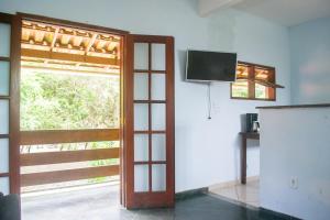 a room with a door and a tv and a window at Sobrado dos Pássaros in Arraial do Cabo