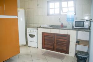 a kitchen with a stove and a microwave at Sobrado dos Pássaros in Arraial do Cabo