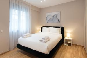 ein Schlafzimmer mit einem großen Bett mit Handtüchern darauf in der Unterkunft Athenais Luxury Apartment in Athen