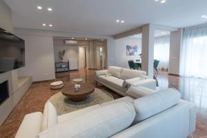 un soggiorno con 2 divani bianchi e un tavolo di Athenais Luxury Apartment ad Atene