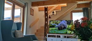 a living room with a tv and a staircase at Wooden House Gabra in Podnart