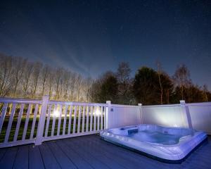 een hot tub die 's nachts op een terras zit bij Tarn Lodge with Hot Tub in York