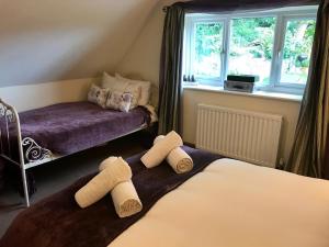ein Schlafzimmer mit zwei Betten mit Handtüchern darauf in der Unterkunft Turnpike Cottage in Tetbury