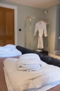 a room with two beds and a shirt hanging on a wall at The Nog Inn in Wincanton