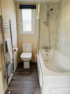 une salle de bain avec toilettes et baignoire dans l'établissement Fairview Lodge with Hot Tub, à Barmby on the Moor 6 autres photos