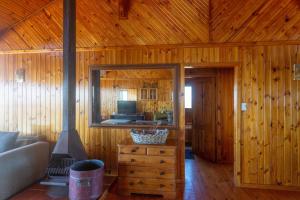 Una sala de estar con paredes de madera y un gran espejo. en Stylish and With Stunning Sea Views, en Cape St. Francis 19 fotos más