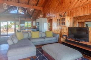Una sala de estar con un sofá y un televisor de pantalla plana. en Stylish and With Stunning Sea Views, en Cape St. Francis