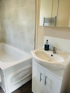 une salle de bain blanche avec un lavabo et un miroir dans l'établissement Fairview Lodge with Hot Tub, à Barmby on the Moor