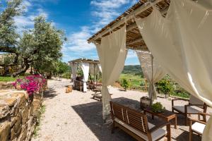 a wedding venue with a stone wall and wooden tables and benches at Agriturismo Schiaccia Ghiande in Massa Marittima