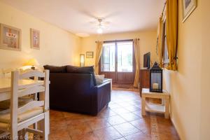 a living room with a black couch and a table at (ROU002) Cómoda Casa con Puerta a la Piscina in Ayamonte