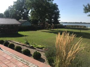 a yard with a garden with a playground at Siedlisko Miluki - Apartamenty nad Jeziorem z Jacuzzi & Sauną in Ełk