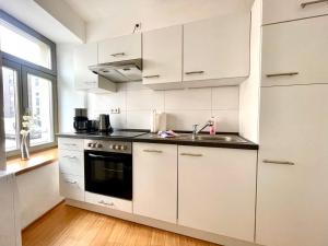 a kitchen with white cabinets and a sink at Gästeapartment Leipzig City in Leipzig