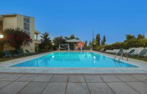 a large blue swimming pool in front of a building at Dreamy Apartments Corfu in Kontokali