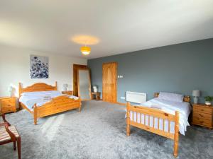 ein Schlafzimmer mit zwei Betten und einer blauen Wand in der Unterkunft Enegar Accommodation in Stromness