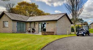 ein Haus mit einem Golfwagen davor in der Unterkunft St Mellion Estate in St Mellion