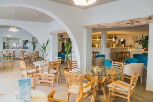 restauracja ze stołami i krzesłami oraz bar w obiekcie Hotel Tagomago w mieście San Antonio Bay
