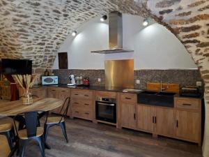 a kitchen with a table and a stove top oven at Moulin de Bonfilhon in Cornillon-Confoux