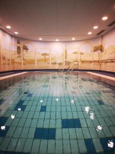 a swimming pool in a hotel with a painting on the wall at Art Hotel Superior in Aachen