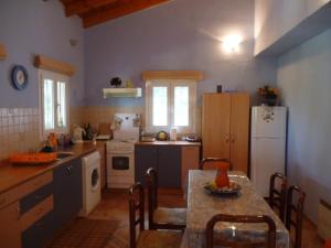 una cucina con tavolo e frigorifero di A Harmony House ad Agia Pelagia Chlomou