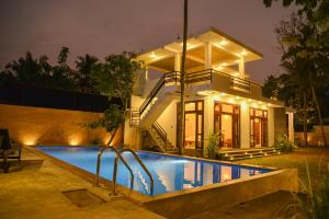 a house with a swimming pool in front of a house at Yehen's Villa in Unawatuna