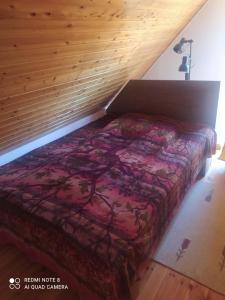 a bed in a room with a wooden wall at Dunahaus in Kimle