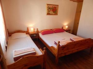 two twin beds in a small room with two lamps at Apartman Megy in Senj