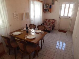 a dining room with a table and chairs and a door at Apartman Megy in Senj