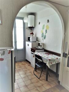 een keuken met een tafel en een aanrecht met een magnetron bij Appartement 1er étage banyuls sur mer départs et arrivées les samedis in Banyuls-sur-Mer