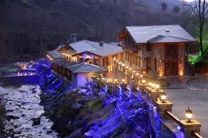 una casa con luces de Navidad frente a un río en Teona Bungalow & Restaurant, en Çiğil