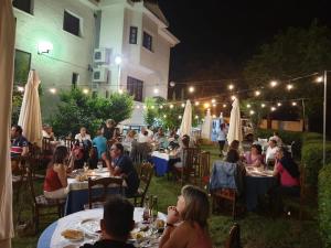 Hostal Asador Julian في برونيتي: مجموعة من الناس يجلسون على الطاولات في الحديقة في الليل