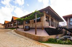 a house with a courtyard in front of it at Hotel Vinícola Davo in Ribeirão Branco