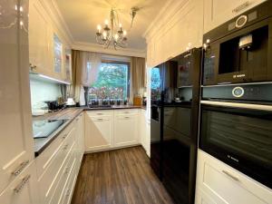 a kitchen with white cabinets and a window at Residence in Dziwnowek in Dziwnówek