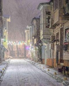 a snow covered street in a city with buildings at Double Q Apart in Istanbul