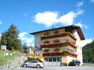 a building with flowers on the side of it at Hotel Alpenfriede in Curon Venosta